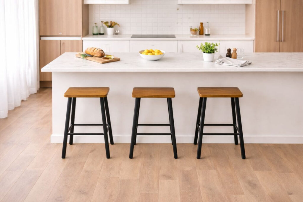 Modern kitchen island with properly spaced bar stools showing correct height and proportions.